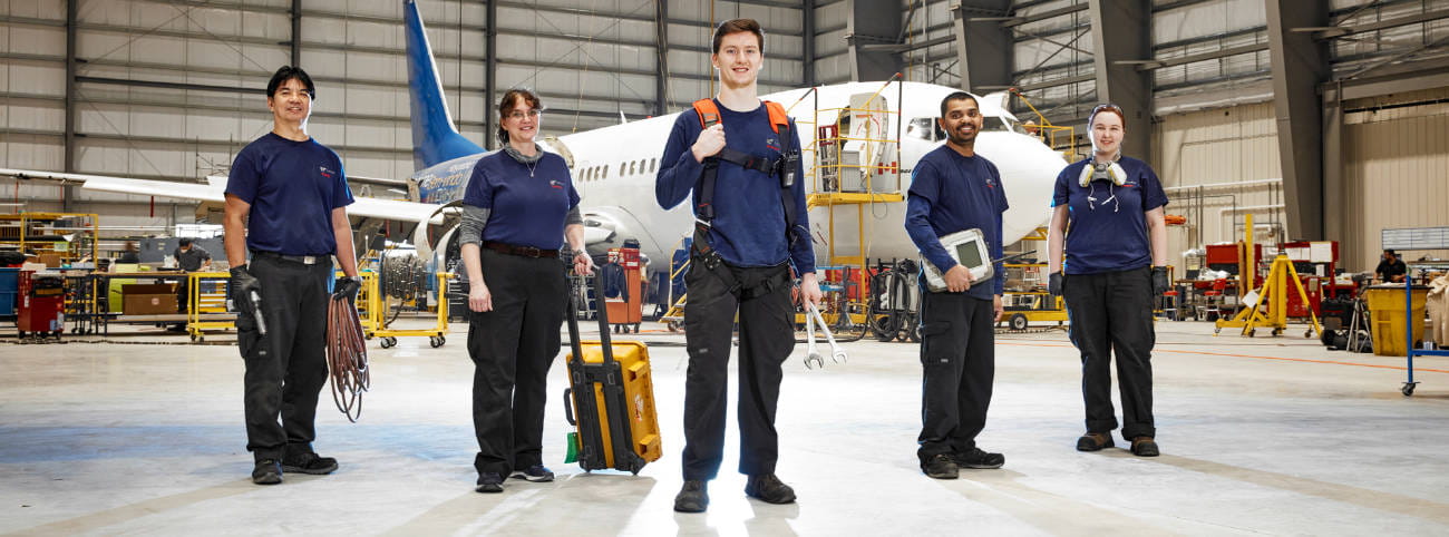 Engineers standing in front of an airplane